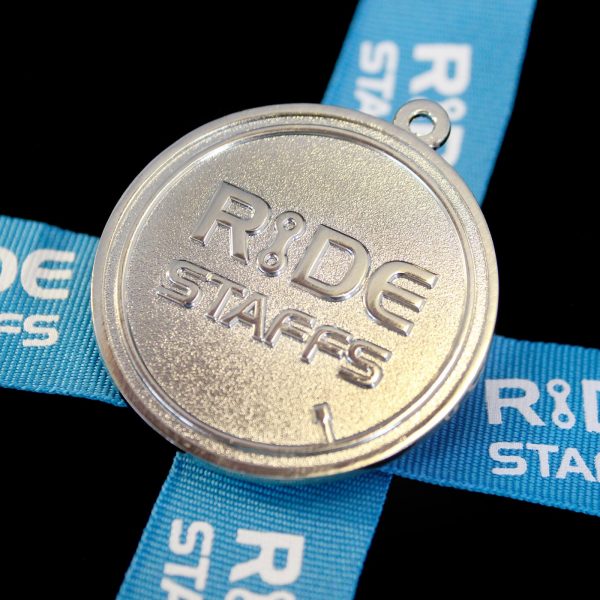 Close up of Ride Staffs Sports Pendant for Leadout Cycling Ltd wuth blue ribbon on black background