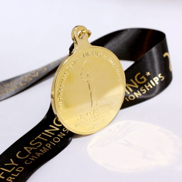 Close up of Gold Fly Casting World Championships 2018 Sports Pendant with ribbon and reflection